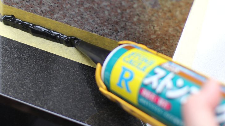 お墓の目地にコーキングを充填しているところの画像