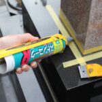 お墓の目地を石材専用のコーキングとガンで施工している画像