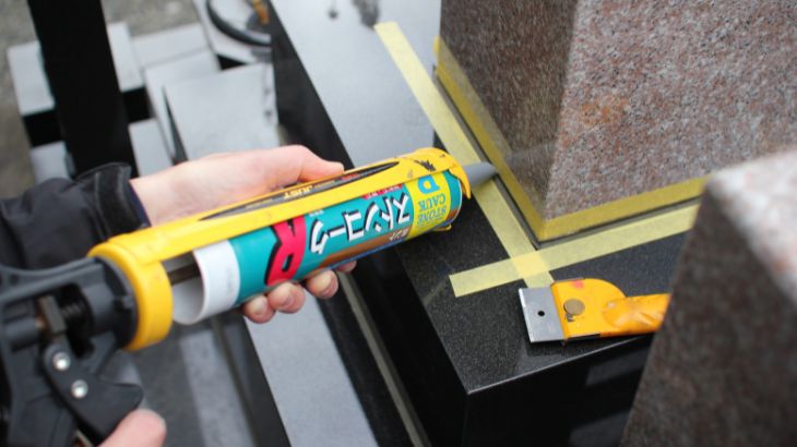 お墓の目地を石材専用のコーキングとガンで施工している画像