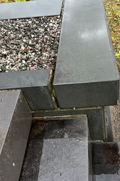 石材店に依頼したほうがよいケース。目地が開いて中に石が入り込んでいる。